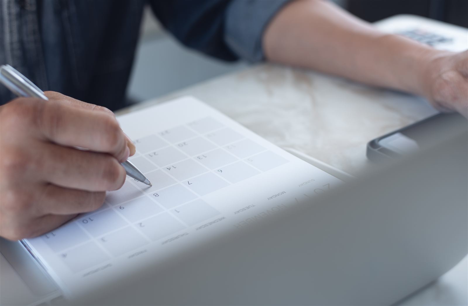 Businessperson marking follow-up dates on a calendar
